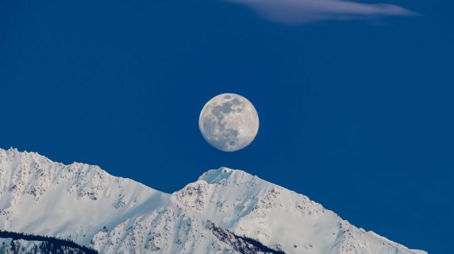 ilustrasi snow moon saat bulan terlihat jelas di malam hari dengan salju