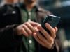 Jepang Gunakan My Number Card di iPhone, Akankah Indonesia Segera Menyusul? Ilustrasi My Number Orang memegang Iphone - sumber foto Istock