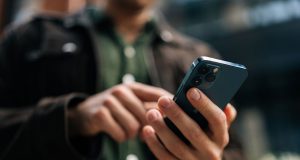 Jepang Gunakan My Number Card di iPhone, Akankah Indonesia Segera Menyusul? Ilustrasi My Number Orang memegang Iphone - sumber foto Istock